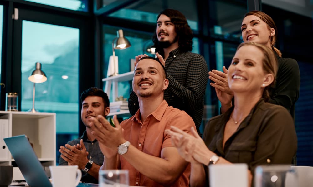 Shot of a group of businesspeople applauding while sitting in the boardroom