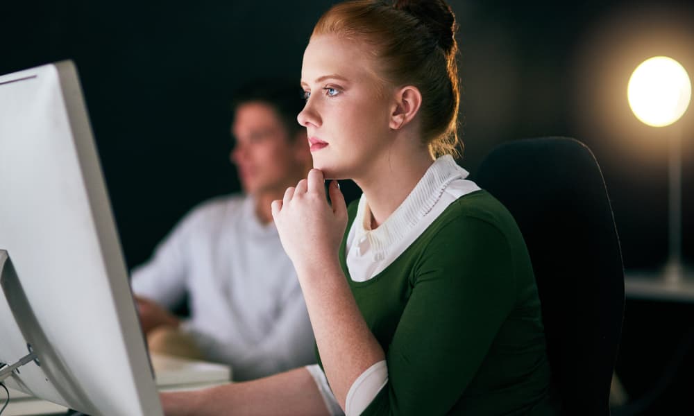 an employee working on a computer looking at an NPS vs. CSAT analysis